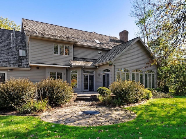 back of house featuring a patio area, a chimney, and a yard