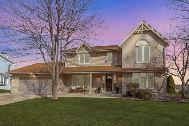 traditional-style house featuring a garage, a yard, a porch, and driveway