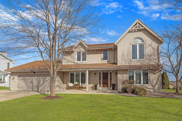 traditional-style home featuring an attached garage, covered porch, a front lawn, and concrete driveway