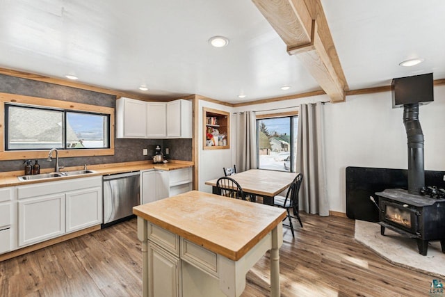 kitchen featuring dishwasher, butcher block countertops, a sink, and light wood-style flooring