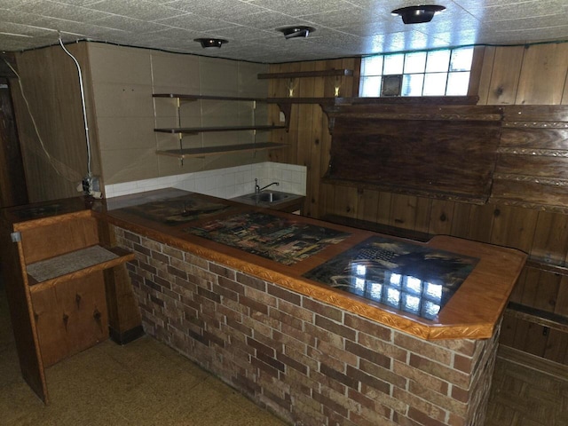 basement with indoor bar and a sink