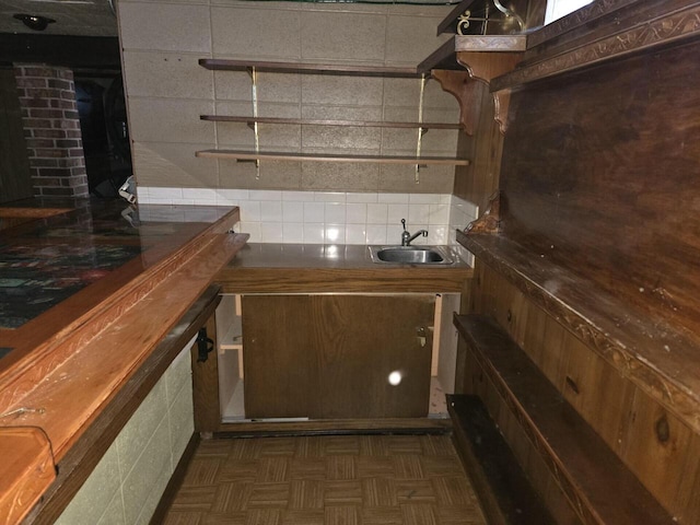 bar featuring tasteful backsplash and a sink