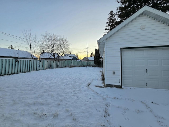 yard layered in snow featuring an outbuilding and fence