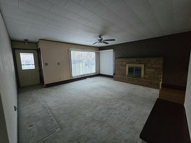 unfurnished living room with a fireplace, baseboards, a wealth of natural light, and carpet flooring