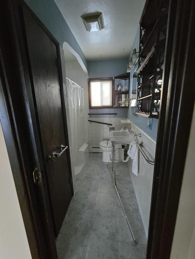 bathroom with curtained shower, visible vents, toilet, wainscoting, and tile patterned flooring