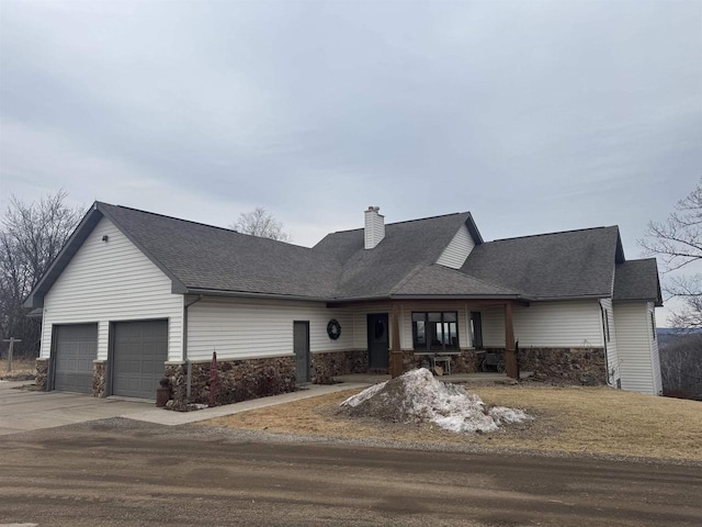 view of front of home featuring a garage, concrete driveway, roof with shingles, and a chimney