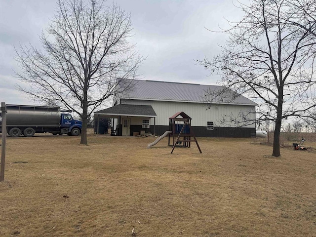 back of property featuring a playground