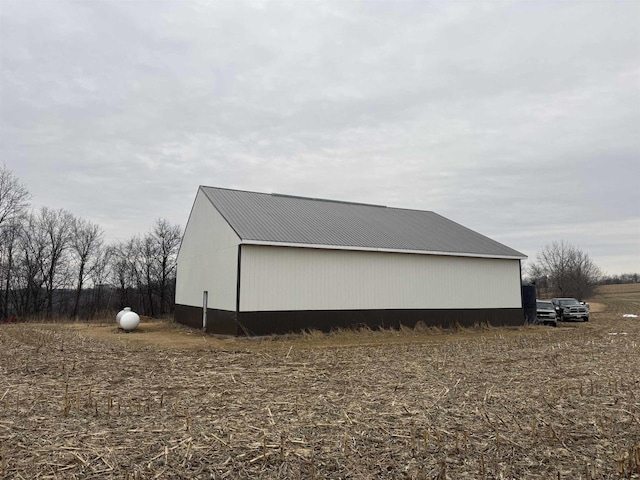 view of side of property with a pole building, metal roof, and an outbuilding