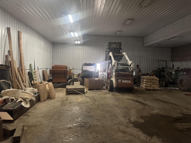 misc room with a garage, metal wall, and concrete flooring