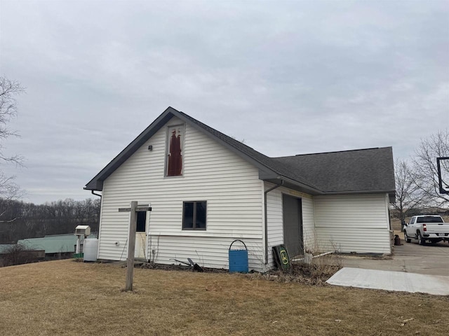 back of house with a yard and roof with shingles