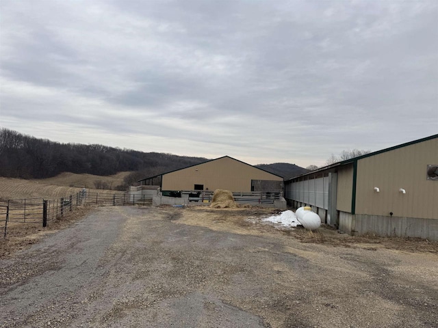 view of yard with an outbuilding, a rural view, and fence