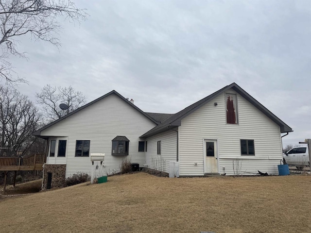 rear view of property featuring a yard and central air condition unit