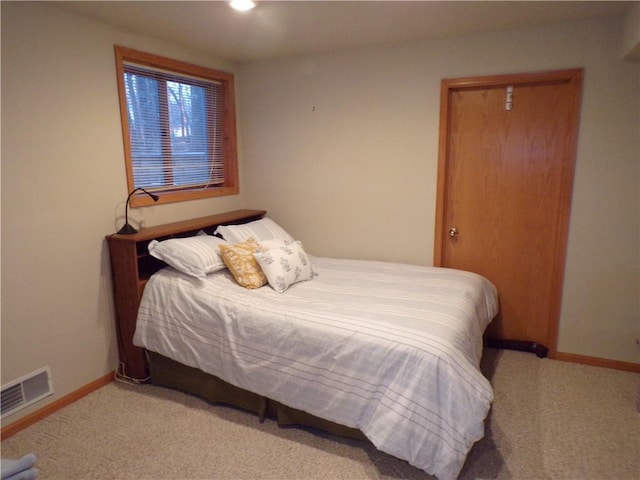 bedroom with visible vents, baseboards, and light colored carpet