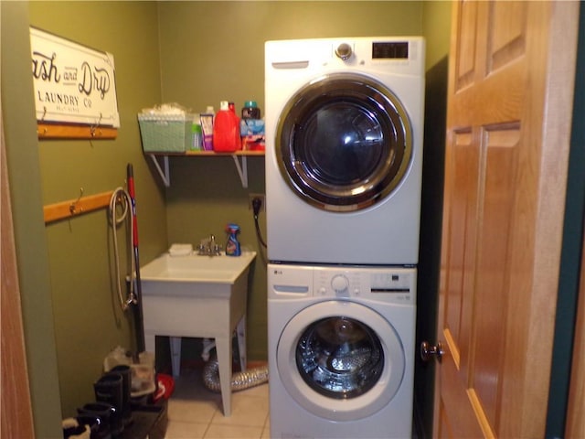 clothes washing area with tile patterned floors, laundry area, and stacked washing maching and dryer