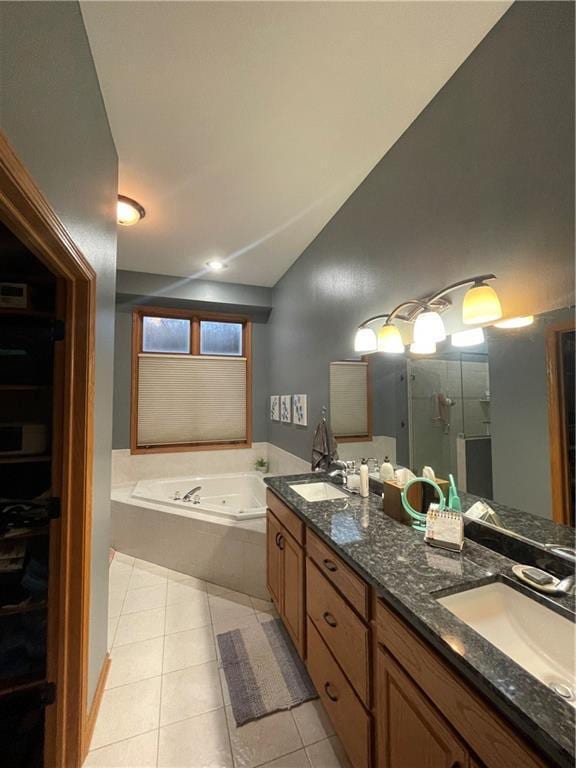 full bath featuring a sink, lofted ceiling, a bath, and tile patterned flooring