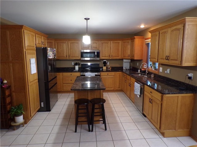 kitchen with a sink, dark stone countertops, a kitchen island, and stainless steel appliances