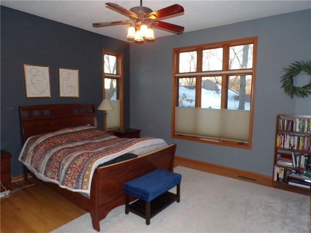 bedroom featuring baseboards, multiple windows, and a ceiling fan