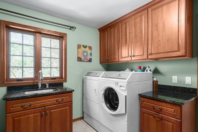 clothes washing area with washing machine and clothes dryer, light tile patterned flooring, cabinet space, and a sink