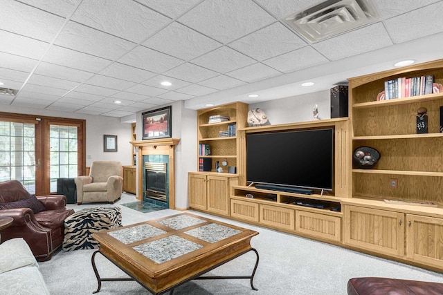 living room featuring visible vents, light carpet, built in shelves, recessed lighting, and a fireplace