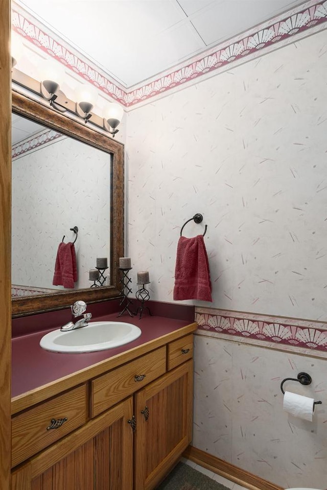 bathroom featuring vanity and wallpapered walls