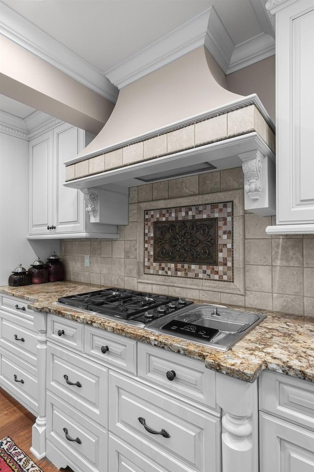 kitchen with white cabinets, wood finished floors, crown molding, and premium range hood