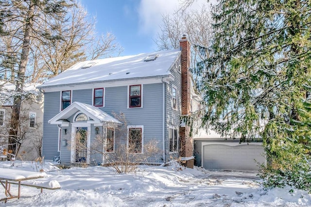 american foursquare style home featuring a garage and a chimney