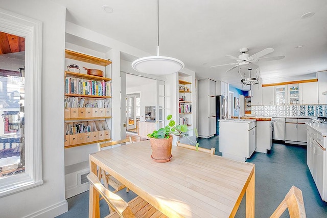 dining area featuring baseboards and ceiling fan