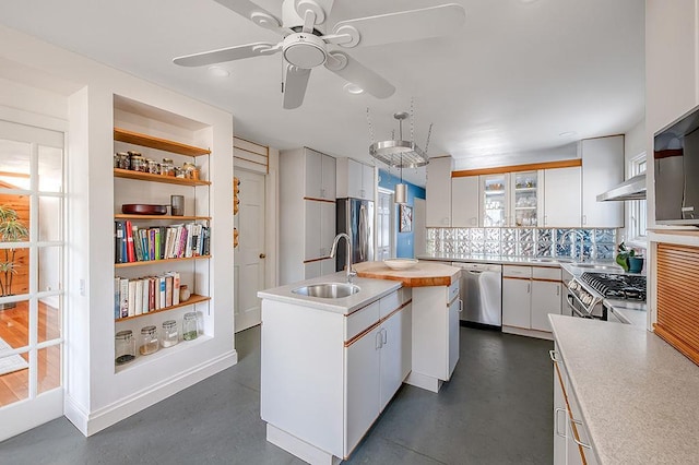 kitchen with a kitchen island with sink, a sink, white cabinetry, appliances with stainless steel finishes, and light countertops