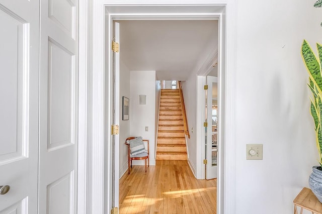 interior space featuring light wood-type flooring, stairway, and baseboards