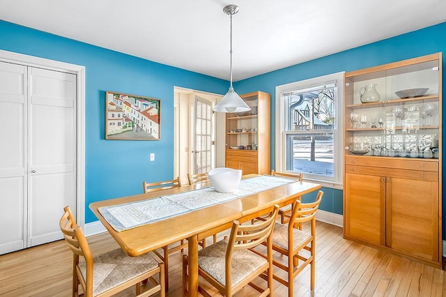 dining area with baseboards and light wood finished floors