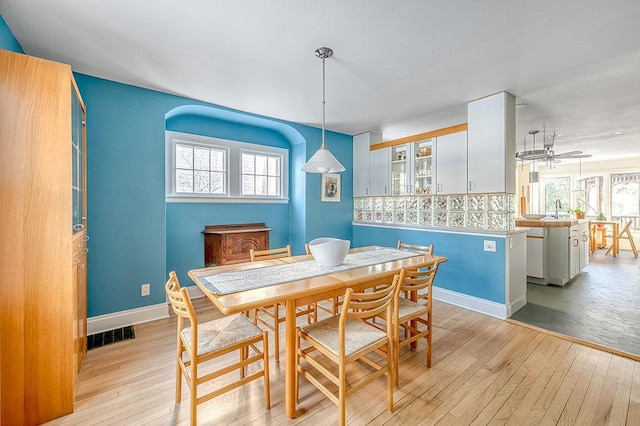 dining space with baseboards, wood-type flooring, and a healthy amount of sunlight