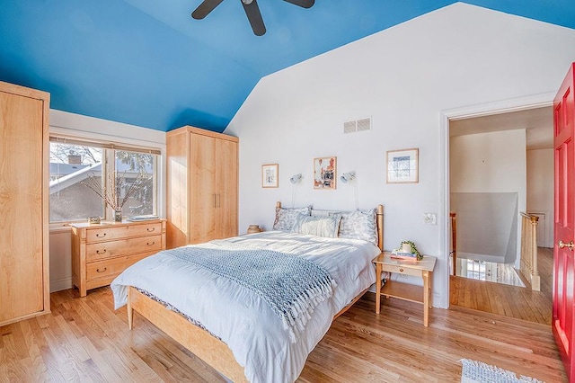 bedroom with vaulted ceiling, a ceiling fan, visible vents, and light wood-type flooring