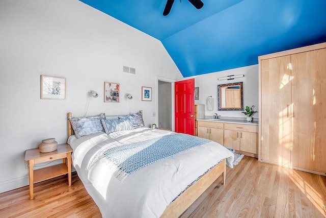 bedroom with visible vents, lofted ceiling, light wood-style flooring, and a ceiling fan