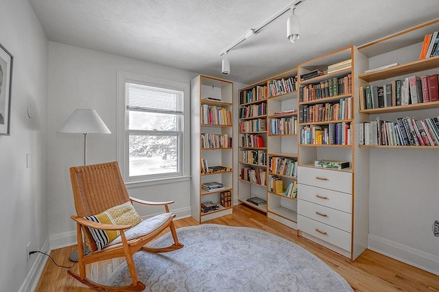 living area featuring light wood-style flooring and baseboards