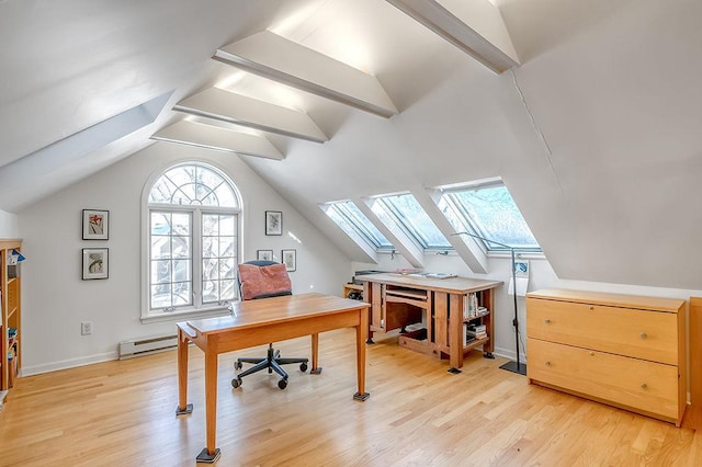 office area with light wood-type flooring, vaulted ceiling with skylight, baseboard heating, and baseboards