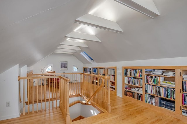 bonus room featuring wood finished floors and vaulted ceiling