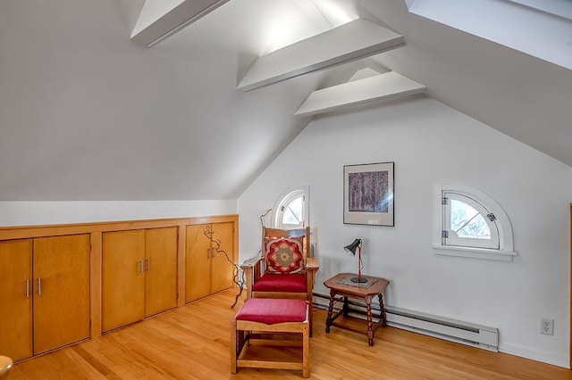 living area featuring plenty of natural light, baseboard heating, vaulted ceiling with beams, and light wood finished floors