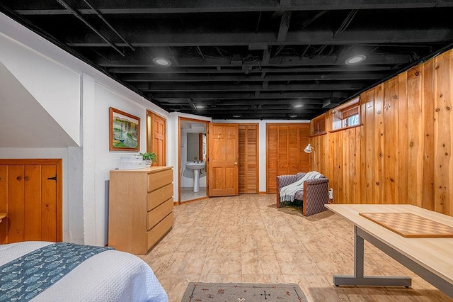 basement featuring wood walls and a sink