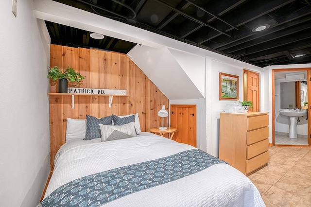 bedroom with wooden walls and a sink