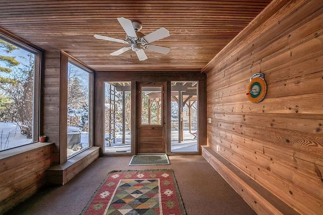 unfurnished sunroom with wooden ceiling and a ceiling fan