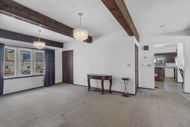 spare room featuring baseboards, beamed ceiling, carpet floors, and an inviting chandelier