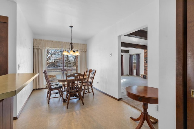 dining area featuring beam ceiling, baseboards, and an inviting chandelier