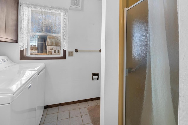 laundry room with light tile patterned flooring, cabinet space, baseboards, and washing machine and clothes dryer