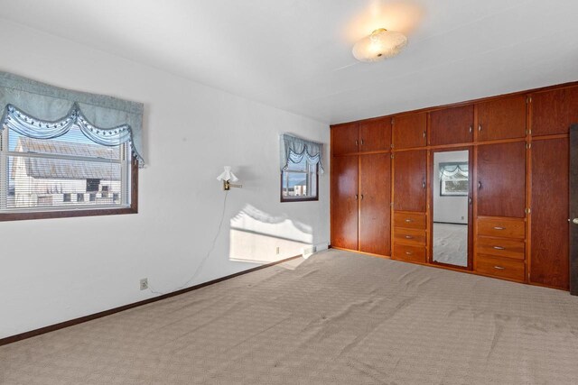 unfurnished bedroom with a closet, baseboards, and carpet