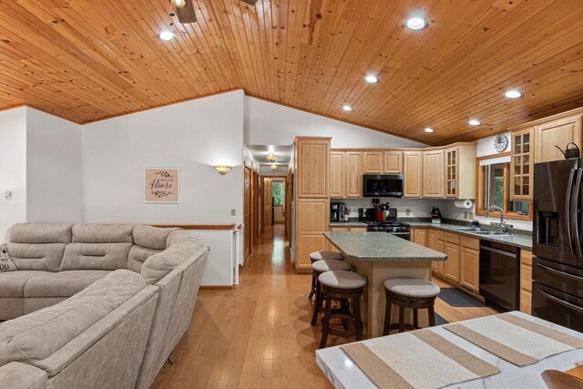 1680 N Aurora Ln, Nekoosa, WI 54457 - kitchen featuring a center island, open floor plan, a kitchen breakfast bar, black appliances, and a sink
