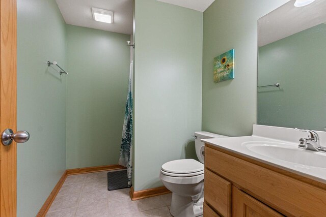 1680 N Aurora Ln, Nekoosa, WI 54457 - full bathroom featuring tile patterned flooring, curtained shower, baseboards, toilet, and vanity