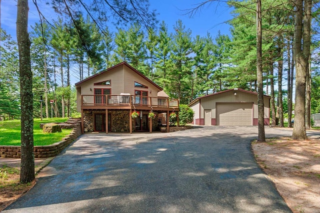 1680 N Aurora Ln, Nekoosa, WI 54457 - rustic home with a detached garage, aphalt driveway, a wooden deck, an outdoor structure, and stone siding