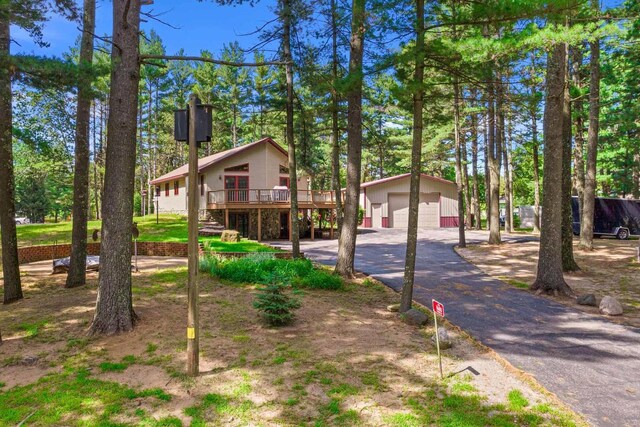 1680 N Aurora Ln, Nekoosa, WI 54457 - view of front of house with aphalt driveway, an outbuilding, a deck, and stairway