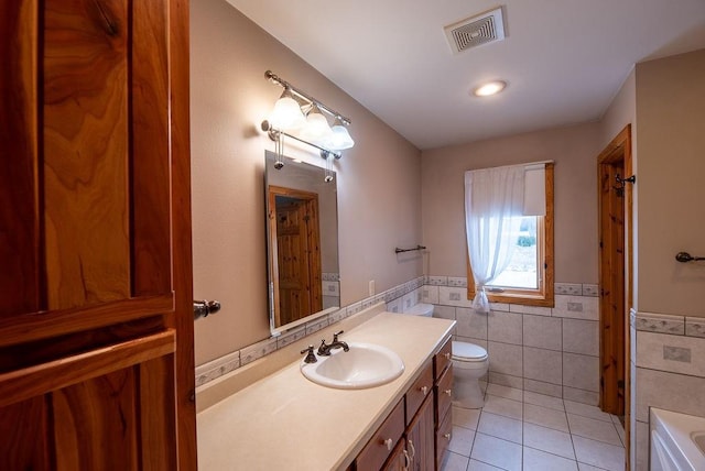 full bathroom featuring visible vents, tile patterned flooring, tile walls, toilet, and a bathtub