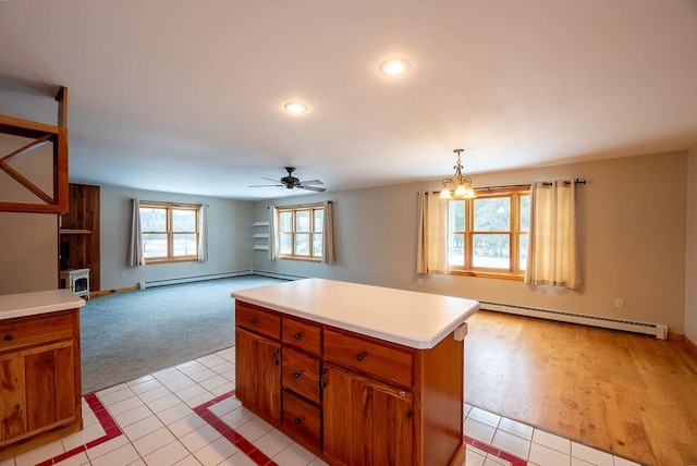 kitchen with brown cabinetry, a kitchen island, light countertops, and a baseboard radiator